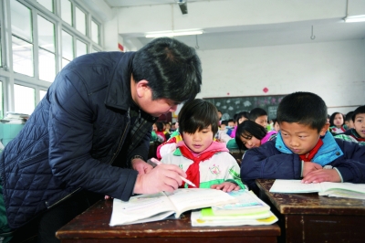 陈运鹏在辅导学生写作业.