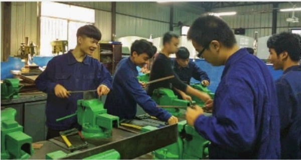 5月12日,邵阳市高级技工学校,学生们身着工作服在车间里上课.